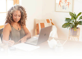 Women sits as desk learning sound healing via computer 