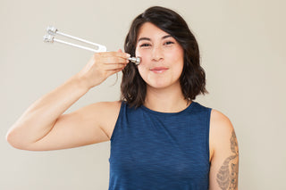 Woman using the Sonic Slider Tuning Fork on cheek