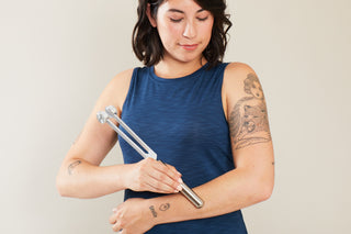 Woman using the Sonic Slider Tuning Fork with Handle Extender