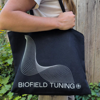 Person carrying the Biofield Tuning Canvas Tote Bag over their shoulder