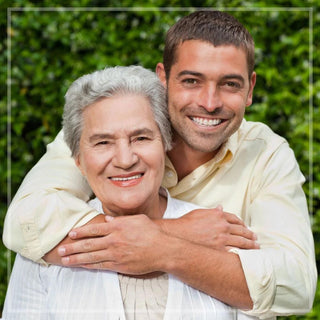 A mother and son pose together against a green backdrop.