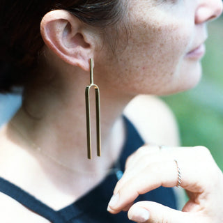 Model wearing Large Handmade Tuning Fork Earrings in solid brass.