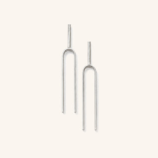 Large Handmade Tuning Fork Earrings in sterling silver on a neutral background. 